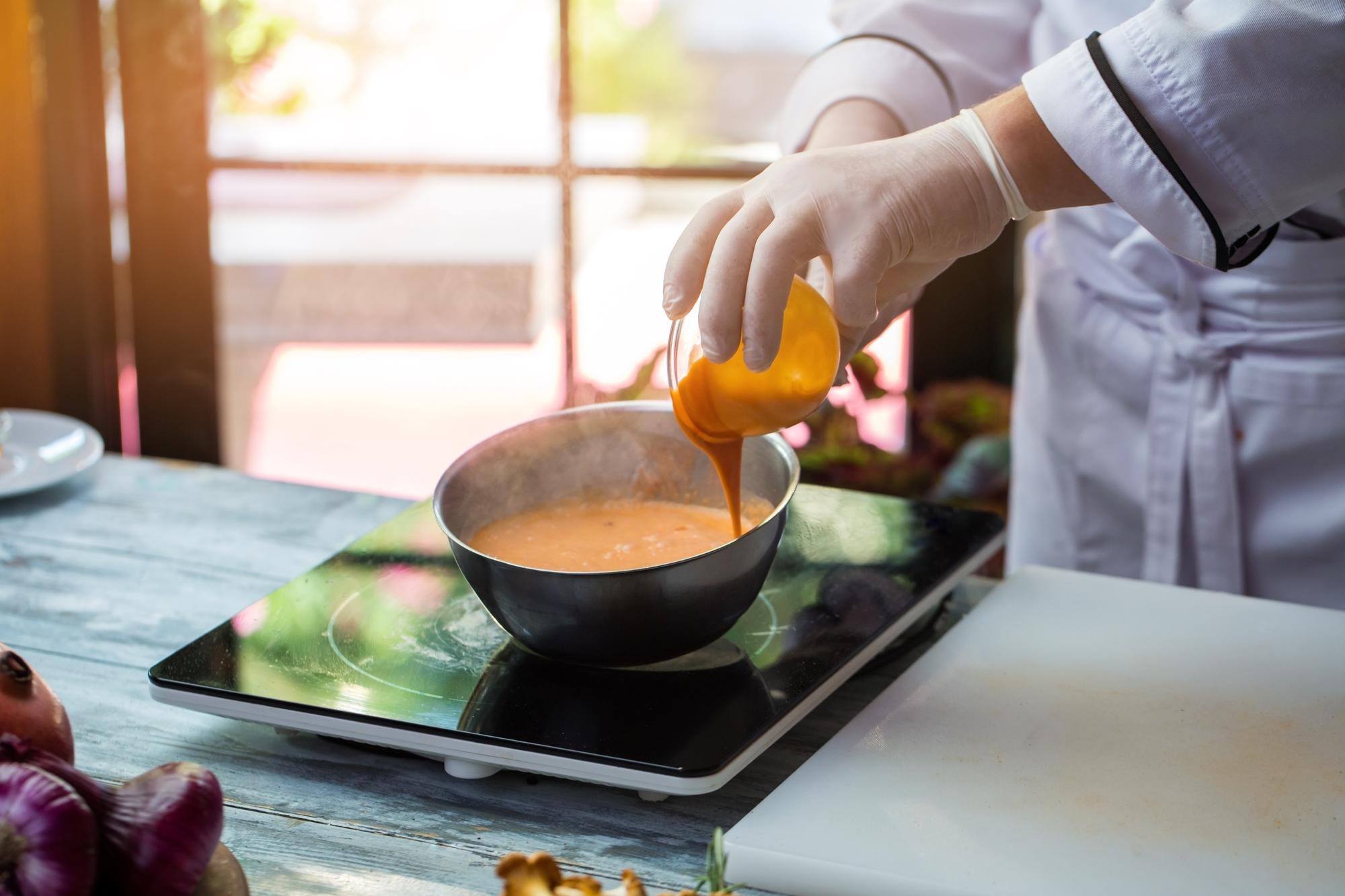 Chef che gira una crema in una casseruola